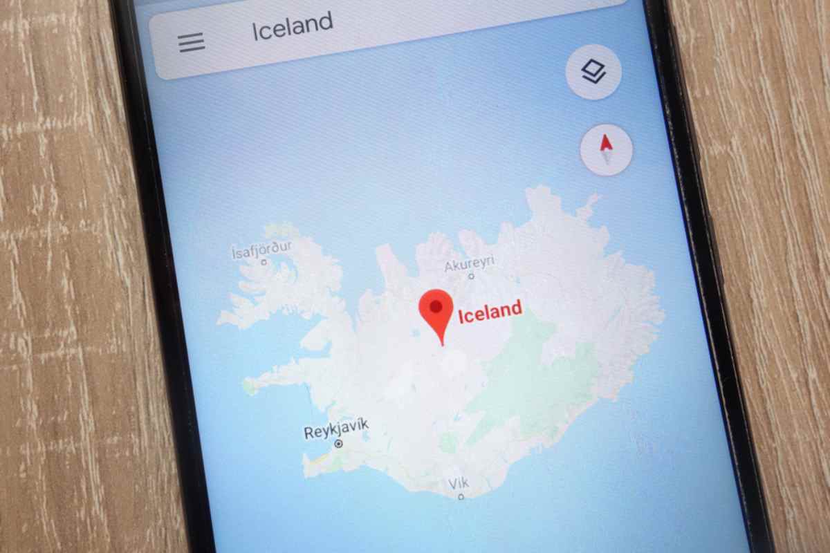 A smartphone screen projecting an online map of Iceland with a location arrow inside the country.