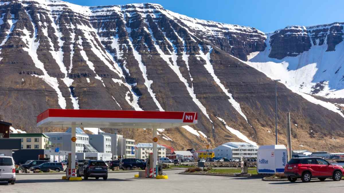General view of an N1 gas station surrounded by snow-capped mountains in Iceland.
