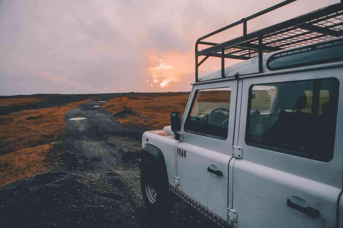 4x4 with roof rack on a rough gravel track at sunrise in the Icelandic Highlands.