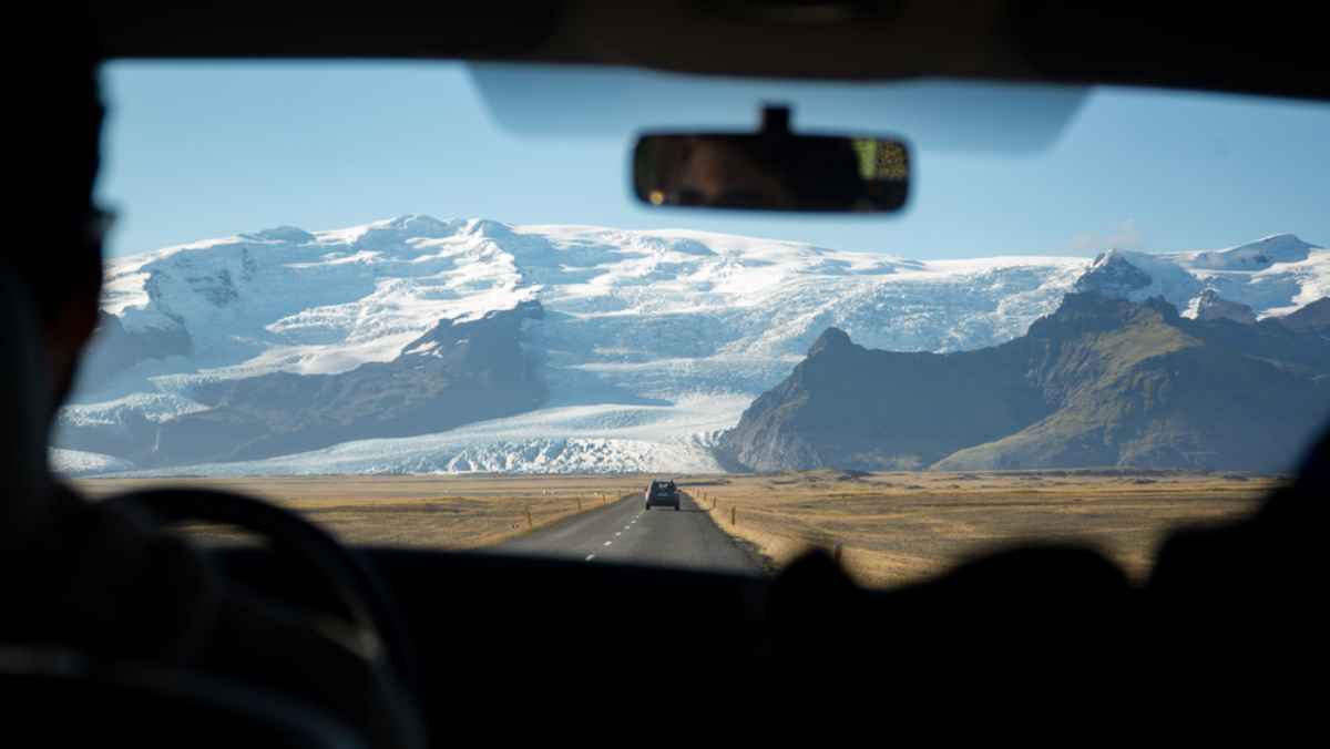 View from a car on Iceland’s Ring Road heading toward glacier-covered mountains.