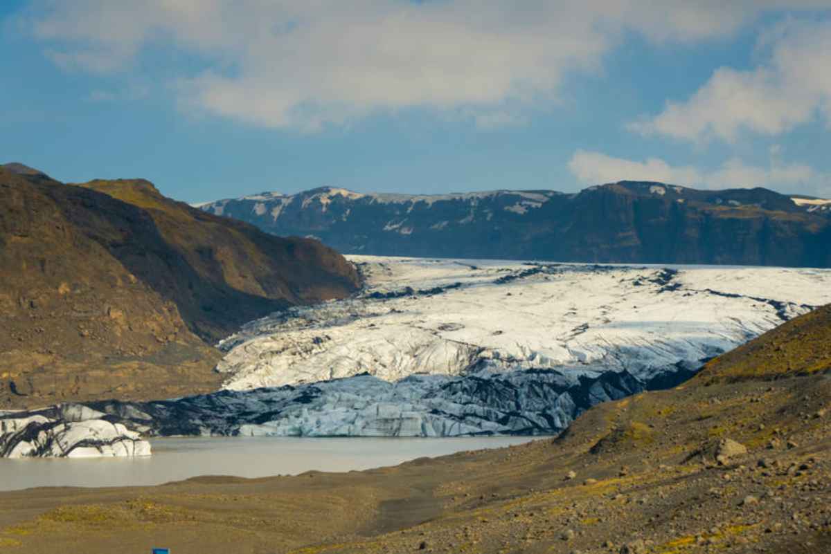 Glacier tongue and milky lagoon framed by dark mountains near the F208 route.
