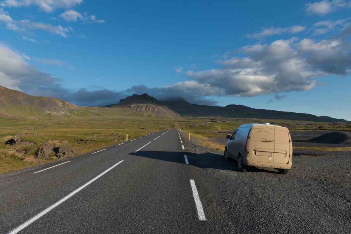 Sandblasted, dust-covered car parked on an Icelandic roadside after strong winds.