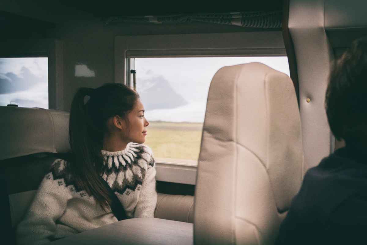 A tourist enjoys the view in Iceland from the back seat of a vehicle.