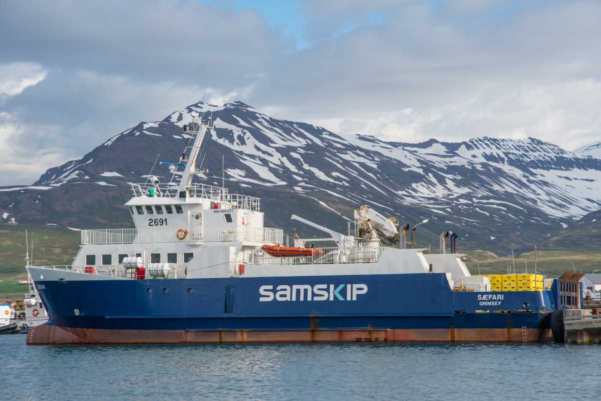 Samskip “S&aelig;fari” ferry docked in harbor with snow-streaked mountains in the background.
