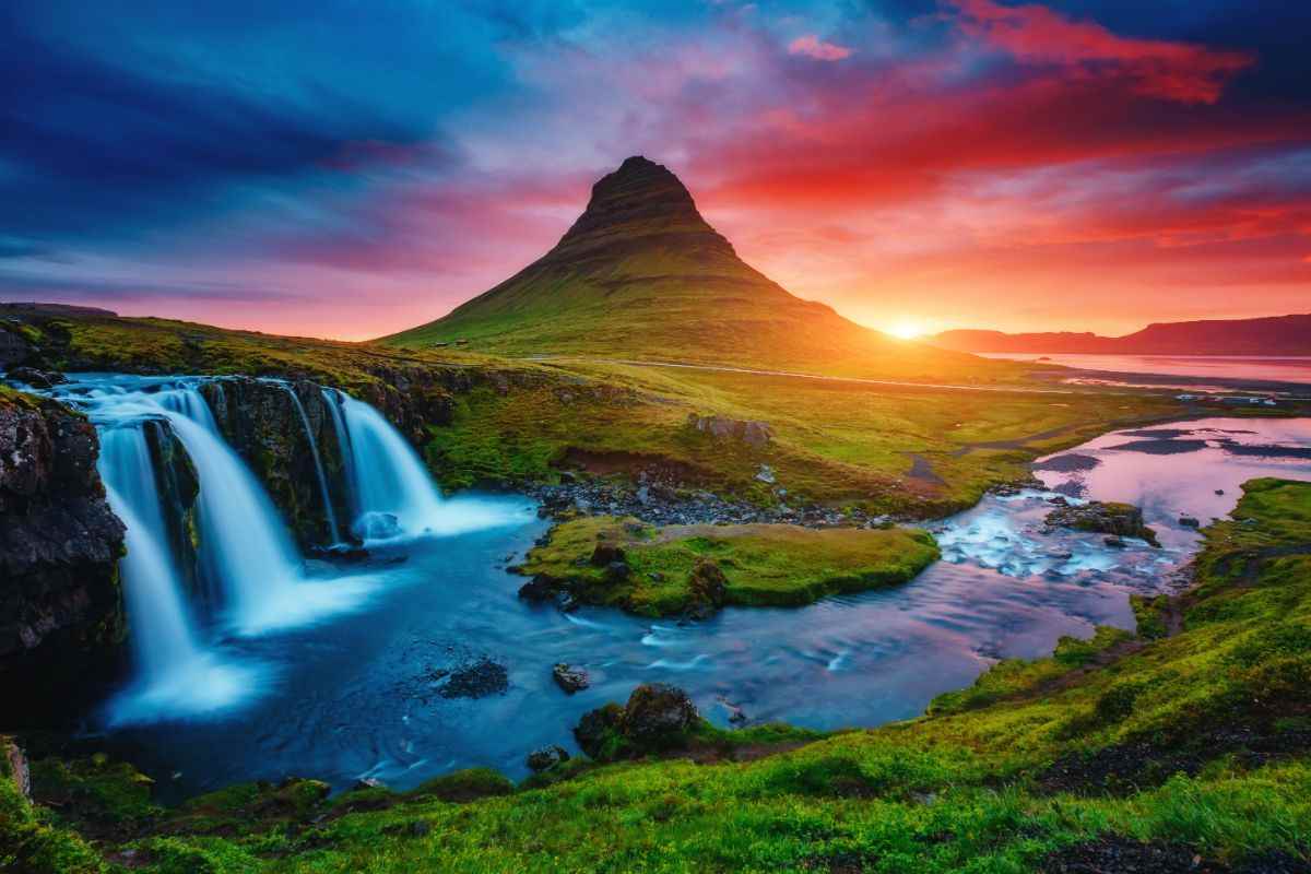 Vivid sunset over Kirkjufell with Kirkjufellsfoss waterfalls and river pools glowing in evening light on Iceland’s Sn&aelig;fellsnes Peninsula.