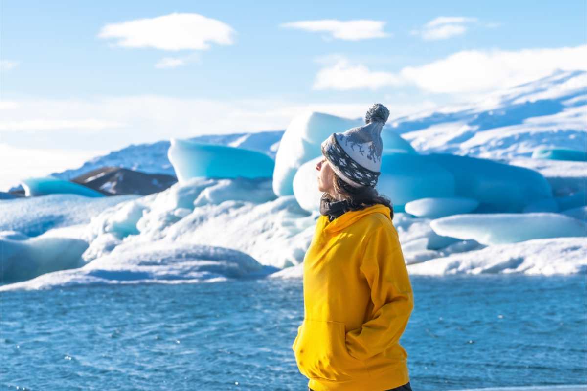 woman enjoying Iceland in March with a snow covered landscape