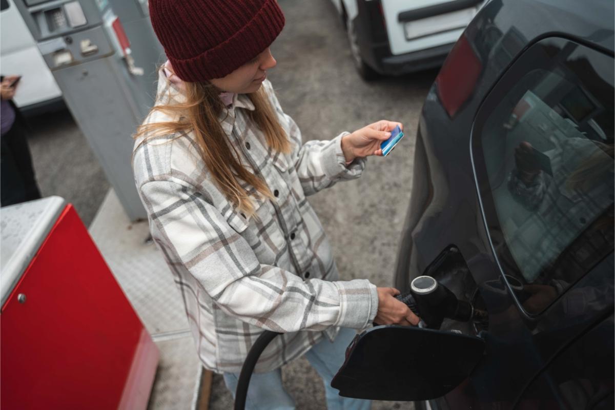 Woman fueling up her rental vehicle in Iceland