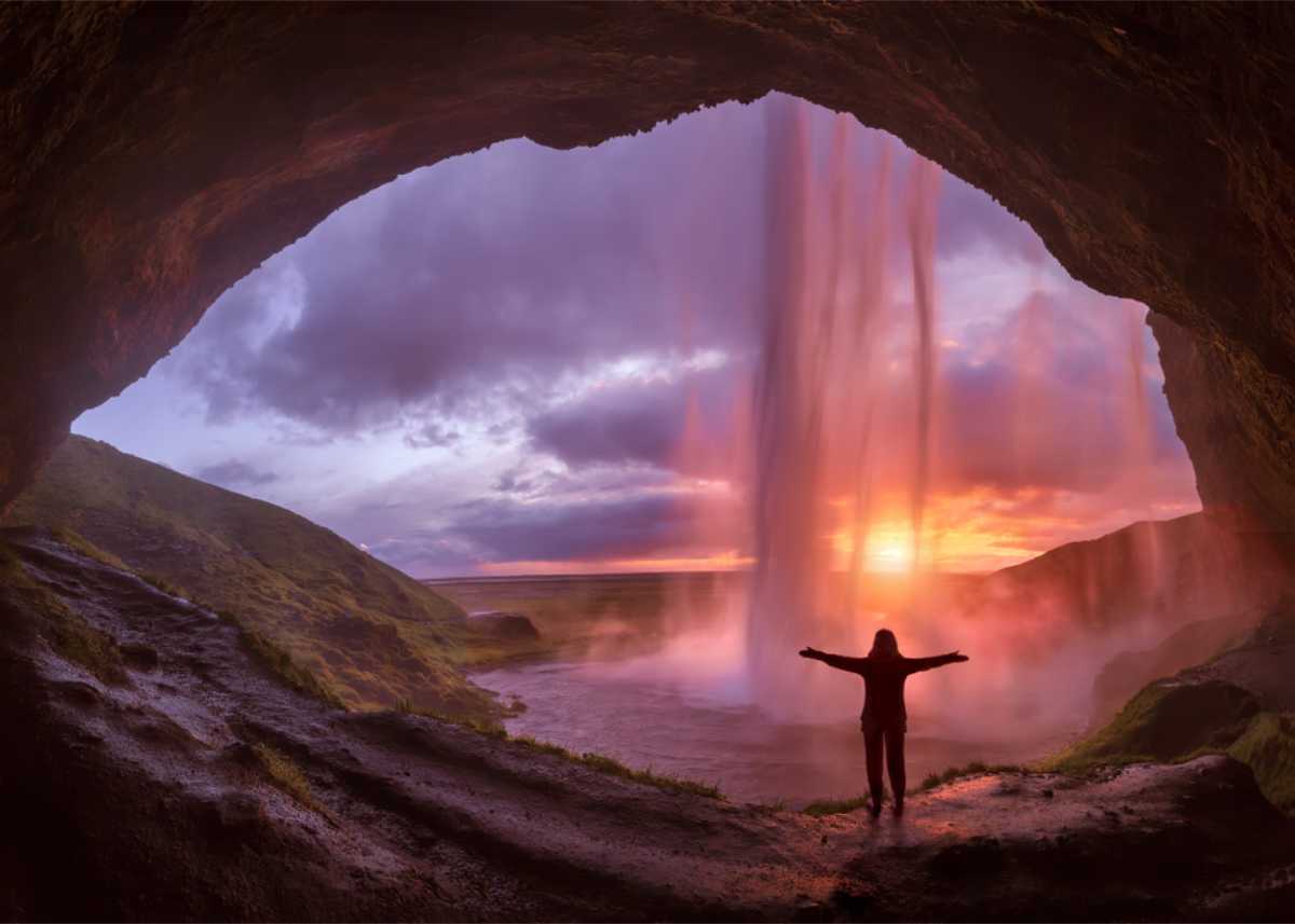 Tourist walking behind Seljalandsfoss waterfall