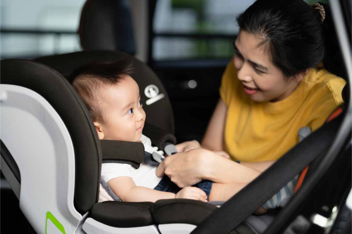 Mother fastening her baby's child seat belts