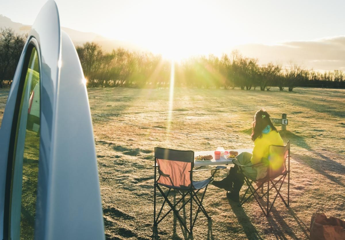 Tourist sitting in her camping set while enjoying the sun