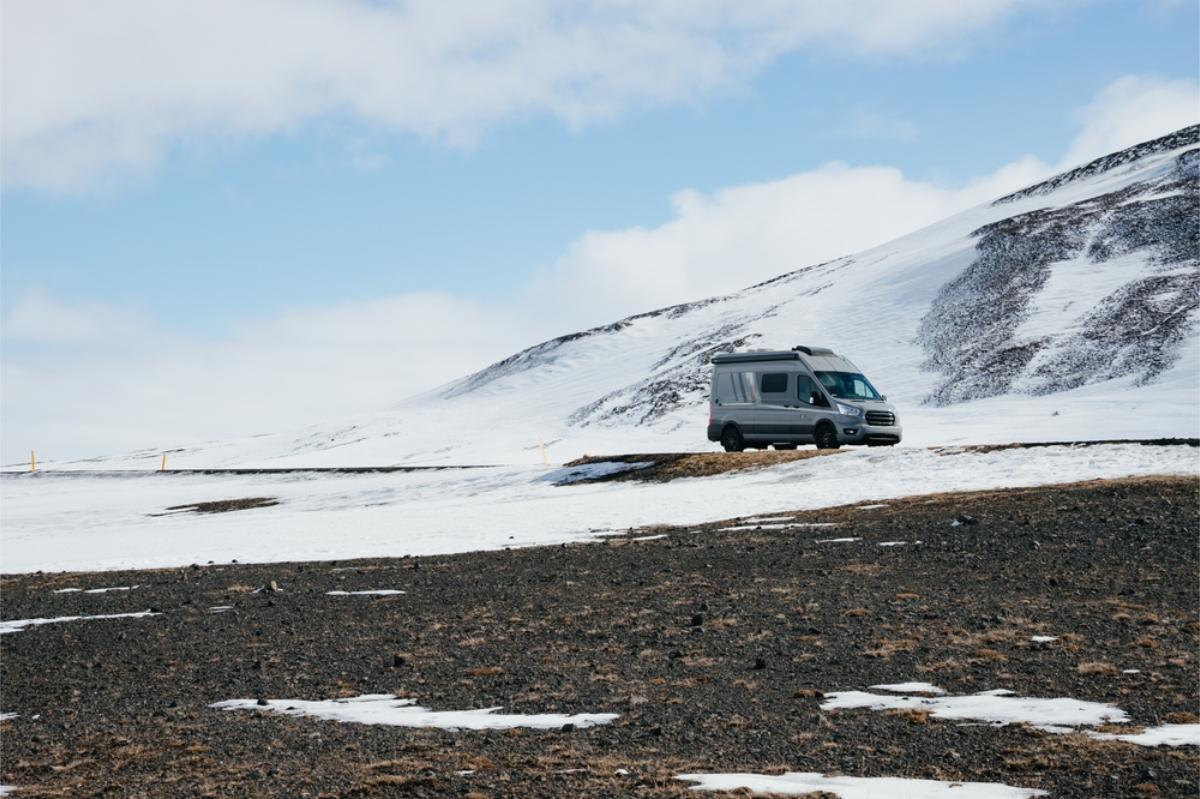 Camper parked by a snowy mountain
