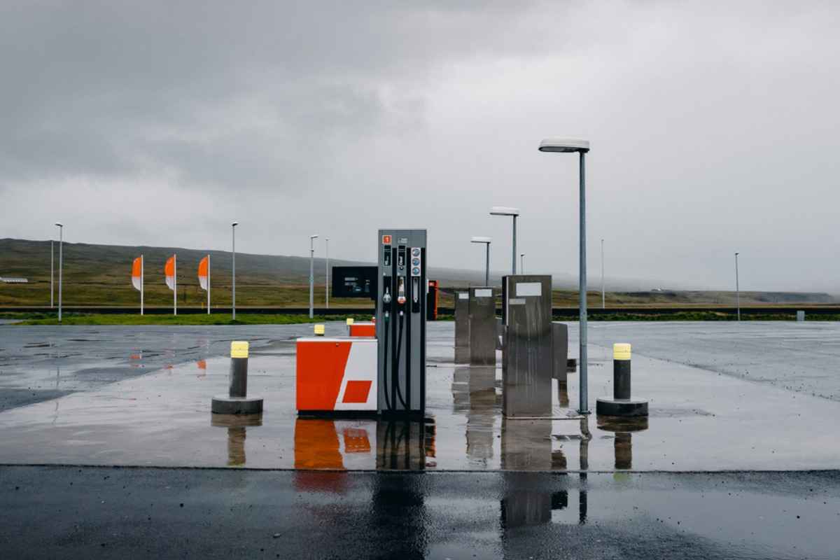 Isolated gas pumps on a rainy Iceland day, wet pavement and gray sky.