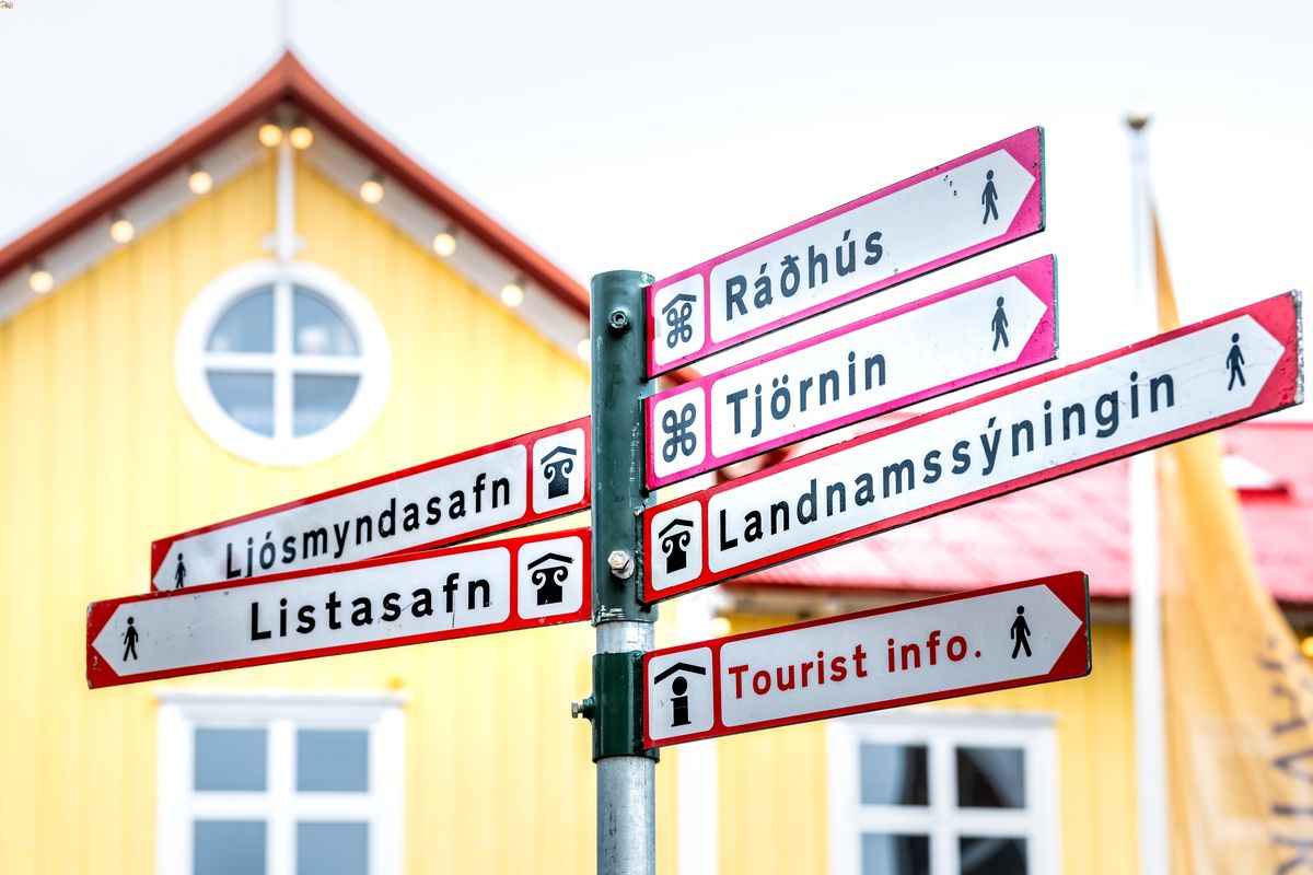 Directional signs in Reykjav&iacute;k pointing to museums, city hall, the pond, settlement exhibition, and tourist info.